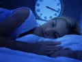 Kobieta leży w łóżku, patrząc w sufit. Obok niej budzik pokazuje późną godzinę. Zastanawia się, jak długo można brać lorafen.