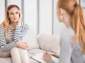 Kobieta na kanapie, zamyślona, podczas sesji, która pokazuje, czym jest psychoterapia.