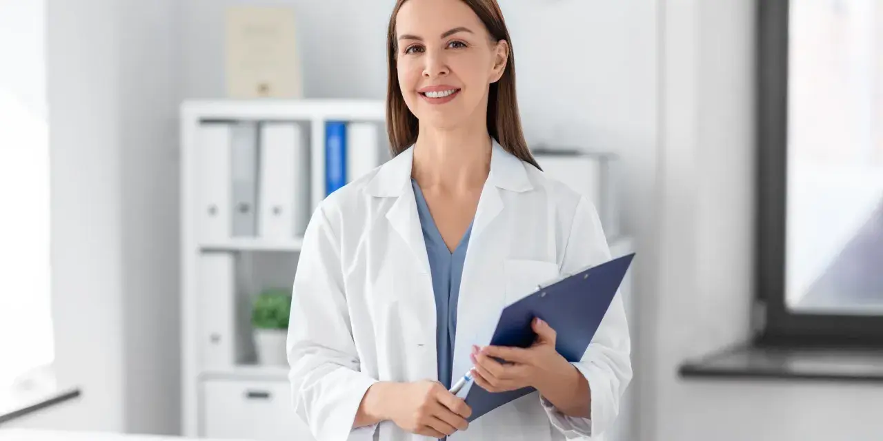 Lekarz rodzinny może wypisać leki od psychiatry, jeśli ma odpowiednie uprawnienia i pacjent posiada skierowanie. Uśmiechnięta lekarka z dokumentacją.
