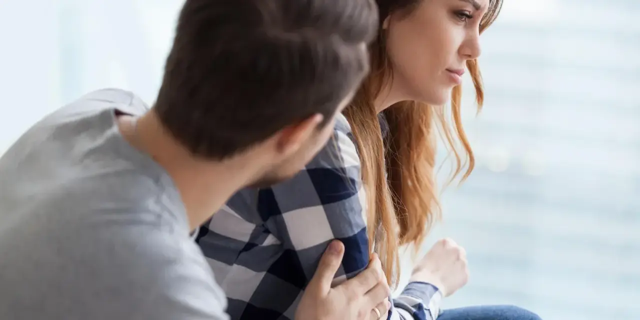 Mężczyzna pociesza kobietę, która zmaga się z trudnościami. Czy zaburzenia adaptacyjne to choroba psychiczna?