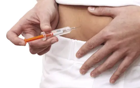 Dłoń przygotowuje zastrzyk z lekiem Neoparin, który jest często stosowany w profilaktyce zakrzepicy.