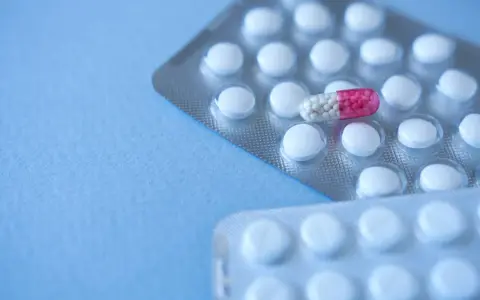 Dwie blistry z białymi tabletkami i jedną kapsułką z różowymi granulkami. Czy to lek Lorafen?