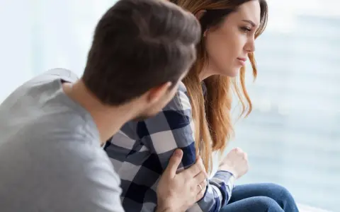 Mężczyzna pociesza kobietę, która zmaga się z trudnościami. Czy zaburzenia adaptacyjne to choroba psychiczna?