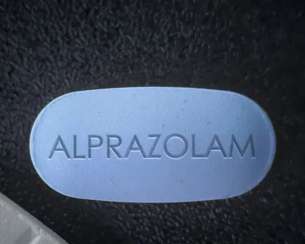 Niebieska tabletka z napisem ALPRAZOLAM. Zastanawiasz się, ile godzin działa afobam?