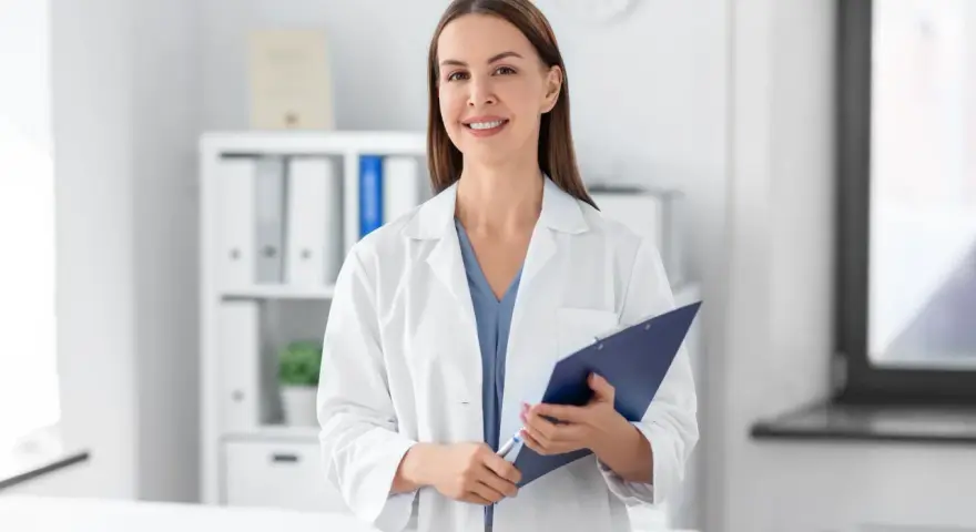 Lekarz rodzinny może wypisać leki od psychiatry, jeśli ma odpowiednie uprawnienia i pacjent posiada skierowanie. Uśmiechnięta lekarka z dokumentacją.