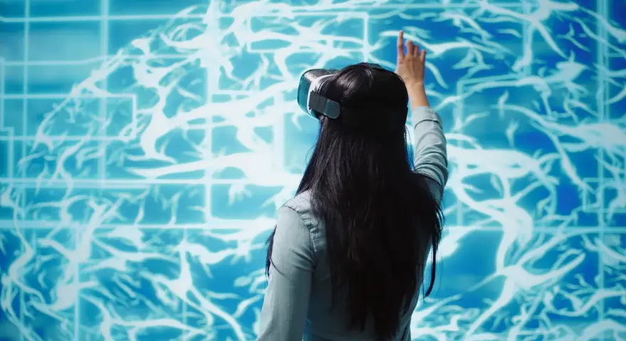Kobieta w goglach VR dotyka wirtualnego mózgu, szukając sposobów na poprawę samopoczucia psychicznego.