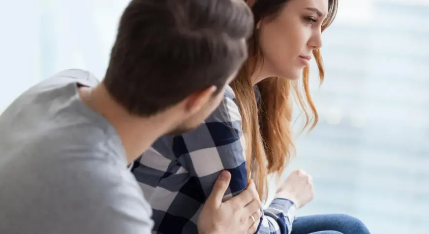 Mężczyzna pociesza kobietę, która zmaga się z trudnościami. Czy zaburzenia adaptacyjne to choroba psychiczna?