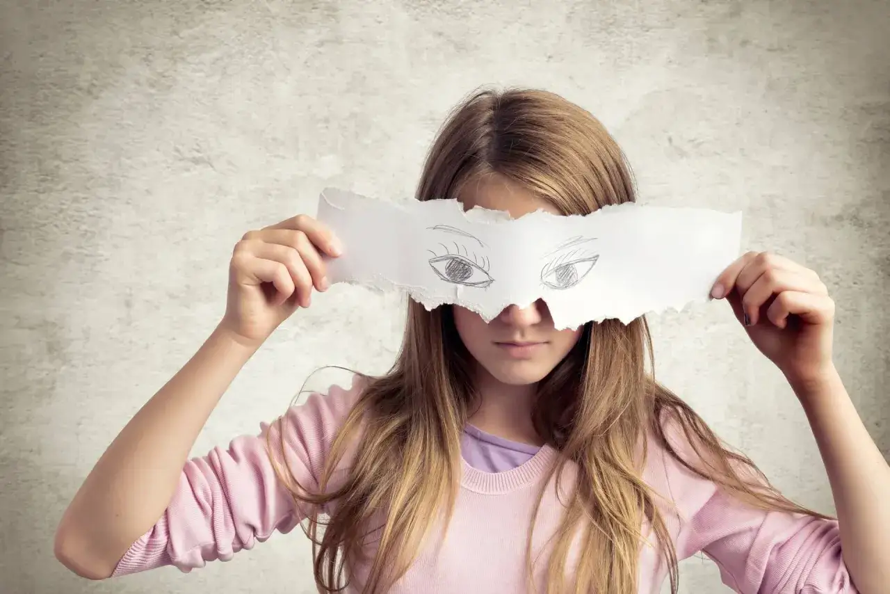 Dziewczynka z papierową maską z narysowanymi oczami. Czy to mitomanka, która ukrywa swoją prawdziwą twarz?