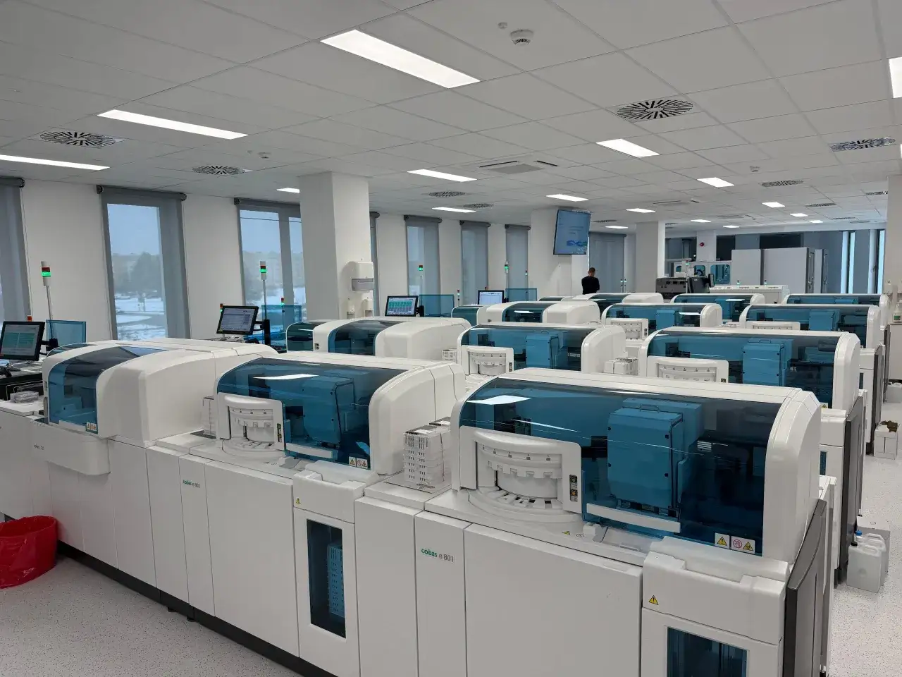 Nowoczesne analizatory laboratoryjne w rzędzie w jasnym pomieszczeniu.
