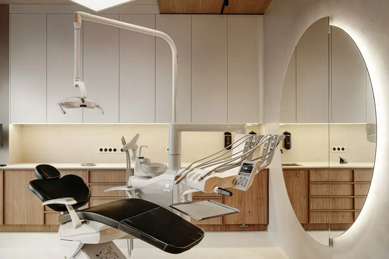 Nowoczesny gabinet stomatologiczny z fotelem dentystycznym i lustrem.